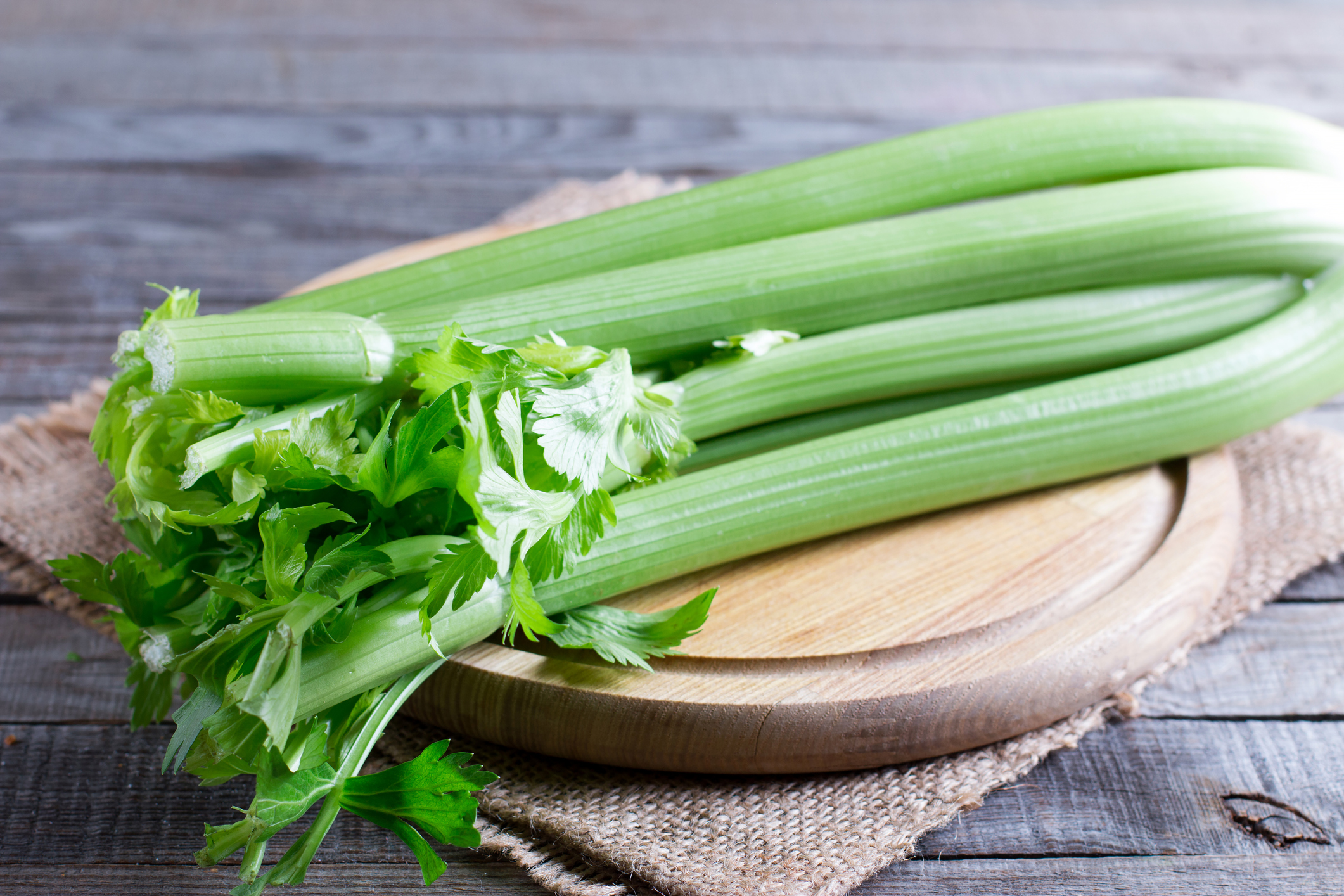 A bunch of celery on a wooden cutting board. 